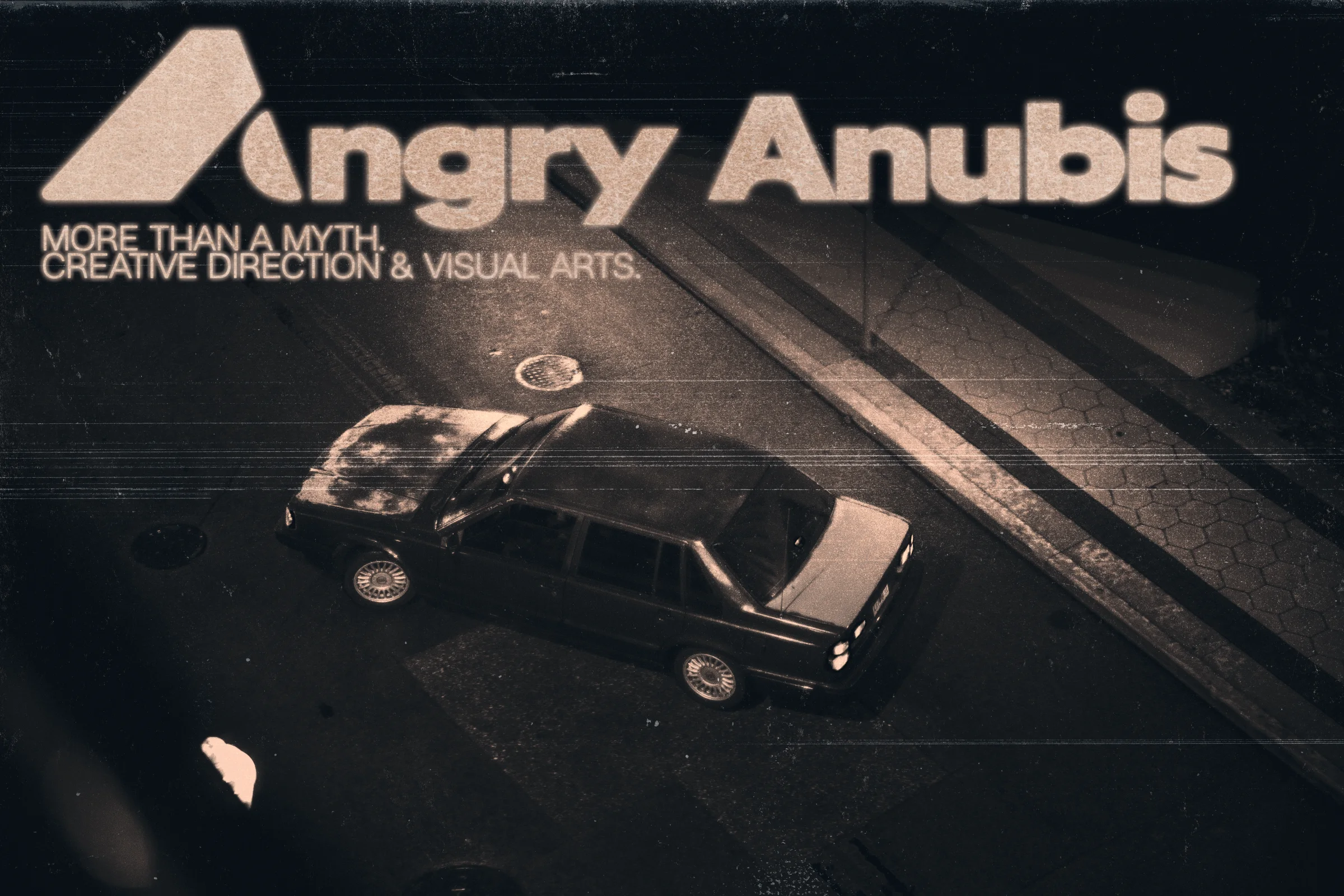 Angry Anubis. More than a myth. Creative direction & visual arts. A textured overhead photograph of a car on a city street.