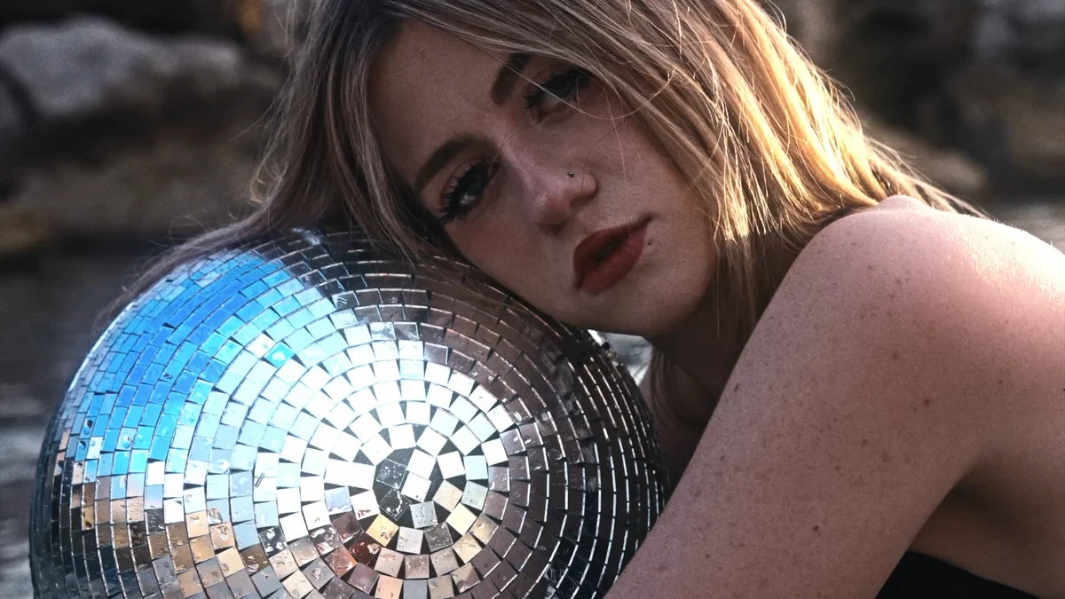 Sunlit beach portrait with a mirrored disco ball